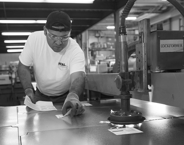 Industrial Worker Cutting Sheet Metal Wearing Protective Eyewear